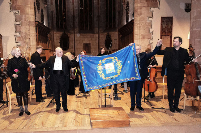 Das Kammerorchester mit der Fahne von Mariupol. | Foto: Horshkova